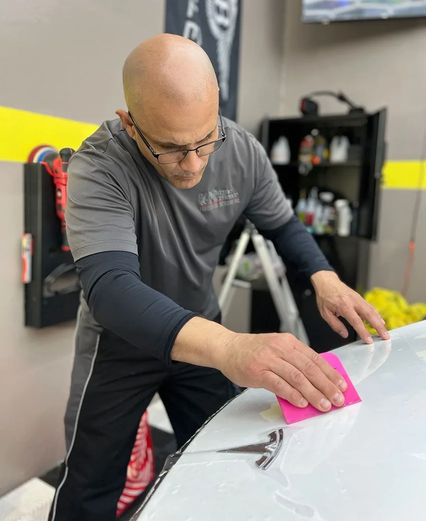 Technician wrapping film around a panel edge